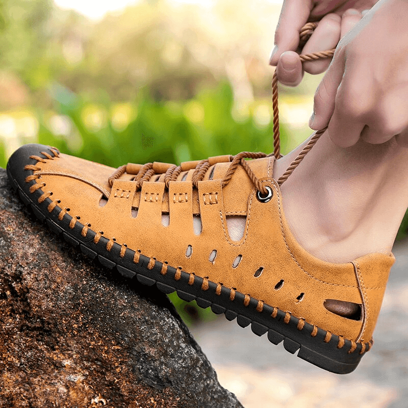 Men's lace-up leather soft sandals on a rock, ideal outdoor water shoes with durable rubber outsole and breathable canvas.